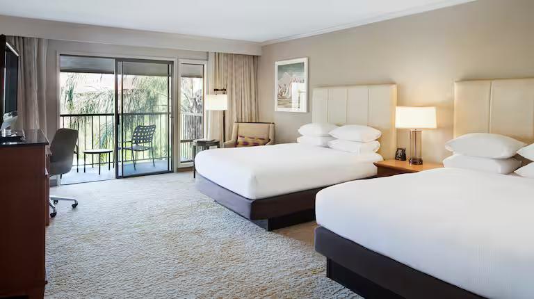 Guestroom with two queen beds and balcony access
