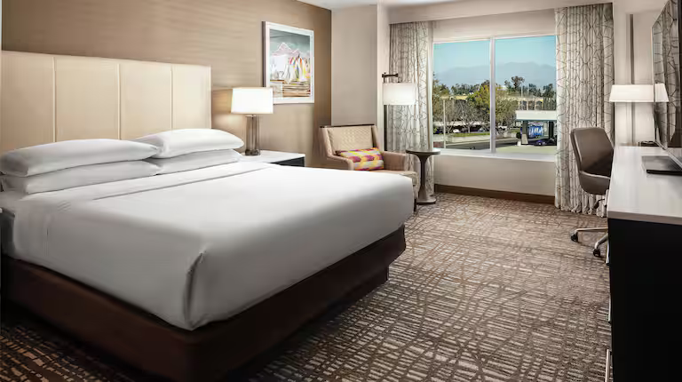 King guestroom with a large window and seating area